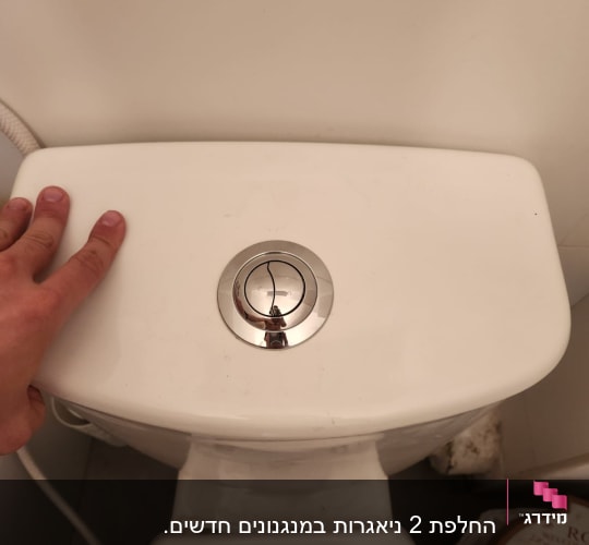 מיכל הדחה עם כפתור כרום ואצבעות יד